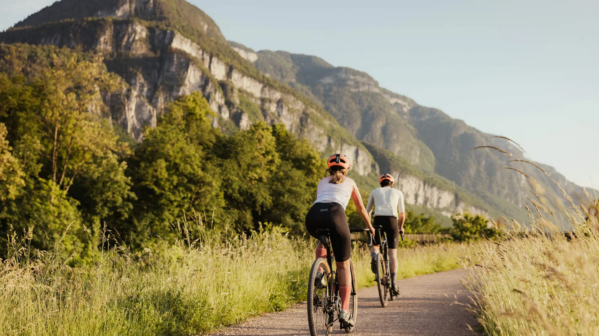 Die schönsten Rennrad-Regionen und Tipps für den Herbst © IDM Südtirol-Alto Adige / Alex Moling Zwei Radfahrer fahren auf einem Weg mit Bergen im Hintergrund