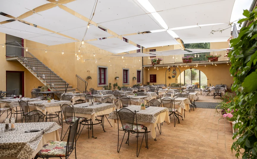Sonnige Terrasse eines Restaurants mit vielen gedeckten Tischen und Stühlen