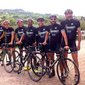 Group of cyclists wearing Lungomare jerseys with road bikes outdoors