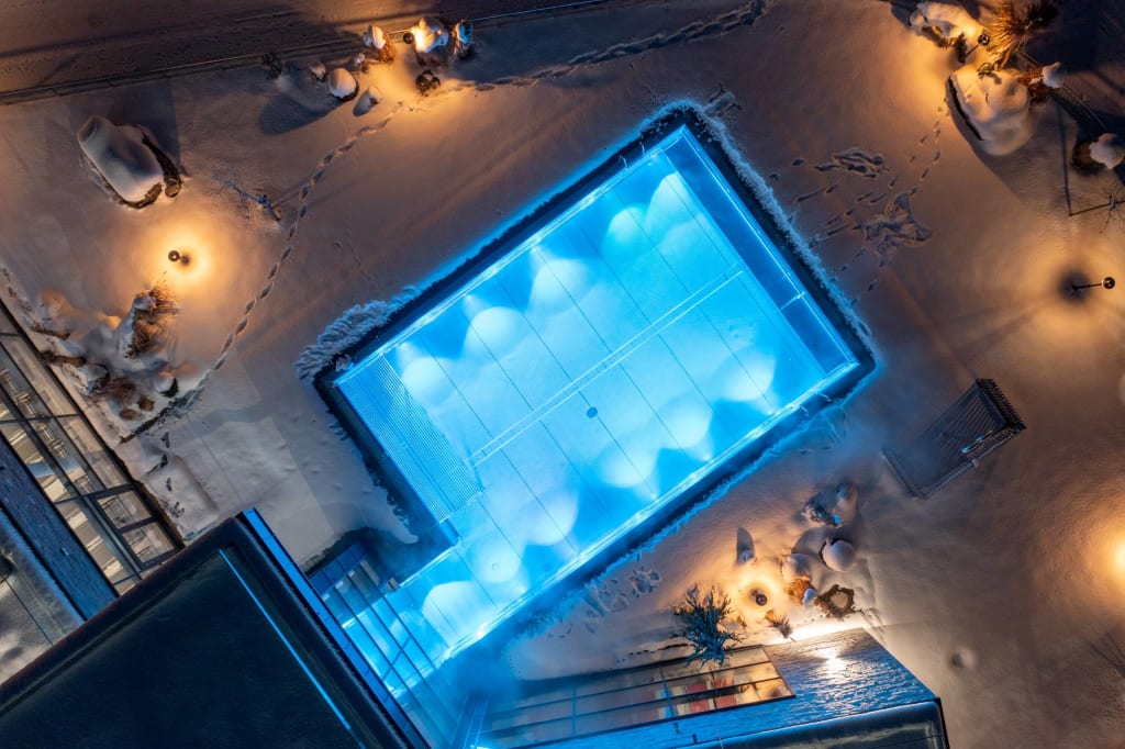 Piscina illuminata nella neve di notte vista dall'alto